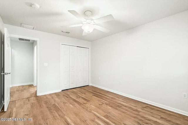 unfurnished bedroom with a ceiling fan, baseboards, visible vents, light wood-style flooring, and a closet
