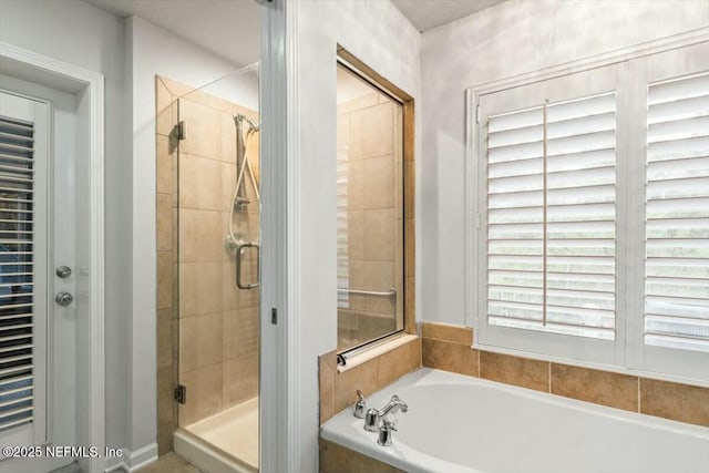 full bathroom with a shower stall and a garden tub