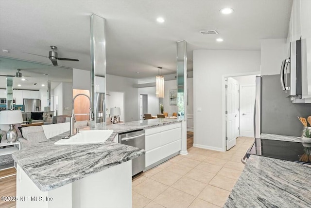 kitchen featuring a sink, ceiling fan, white cabinetry, and stainless steel appliances
