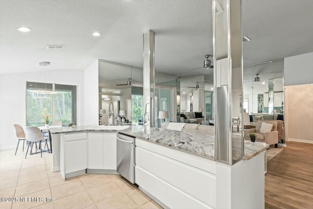 kitchen featuring visible vents, open floor plan, dishwasher, a ceiling fan, and a sink