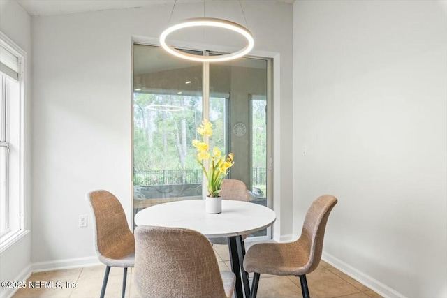 dining space featuring a wealth of natural light, light tile patterned floors, and baseboards