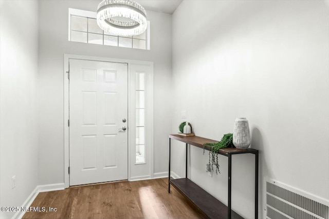 entryway featuring visible vents, baseboards, and wood finished floors