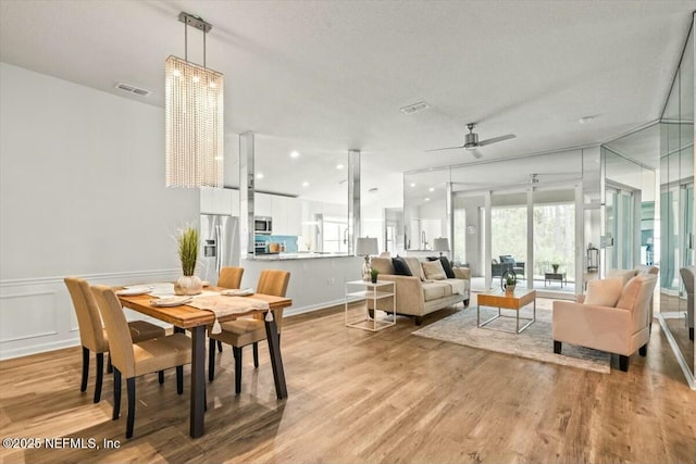dining space featuring plenty of natural light, light wood-type flooring, visible vents, and ceiling fan