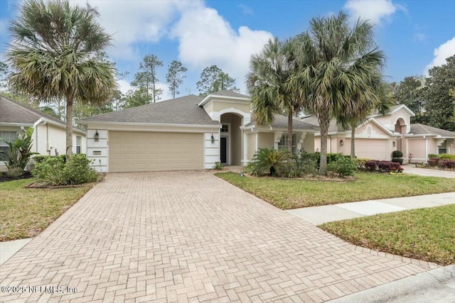 single story home with stucco siding, decorative driveway, a front yard, a shingled roof, and an attached garage