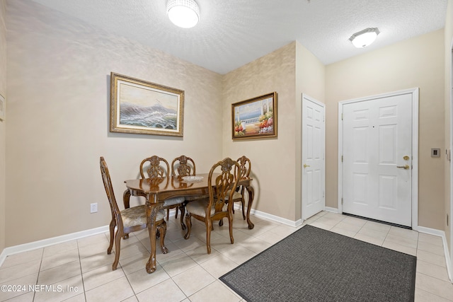 tiled dining space featuring a textured ceiling