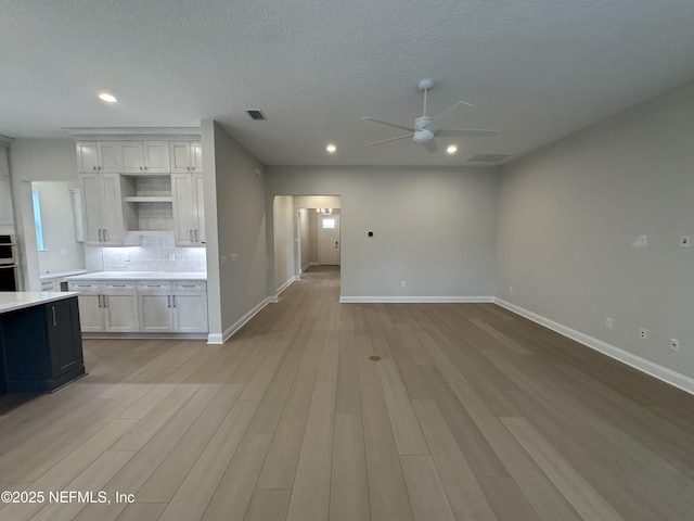 interior space with a ceiling fan, light wood-type flooring, baseboards, and recessed lighting