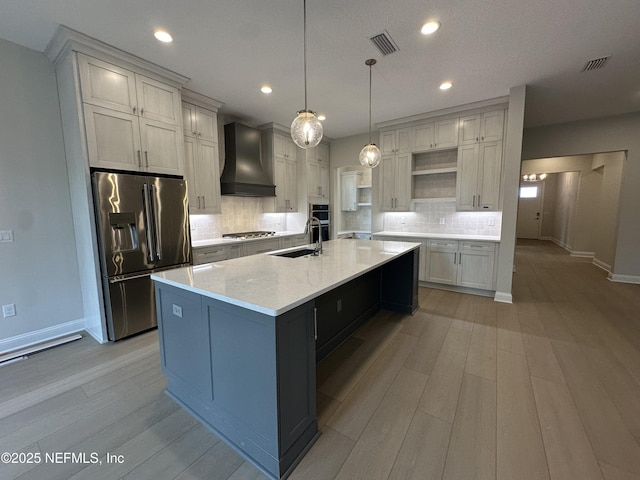 kitchen featuring visible vents, appliances with stainless steel finishes, custom exhaust hood, open shelves, and a sink