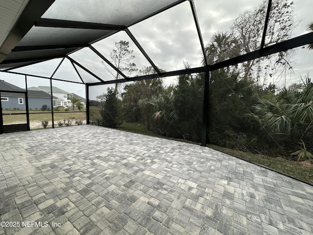 view of patio featuring glass enclosure