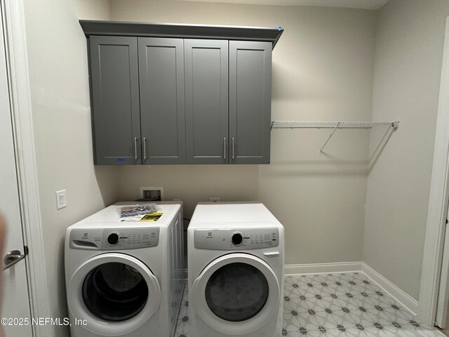 laundry room featuring baseboards, cabinet space, light floors, and separate washer and dryer