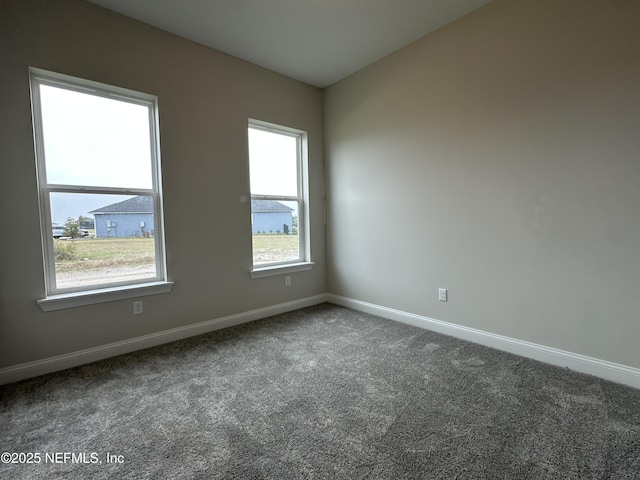 carpeted empty room with baseboards