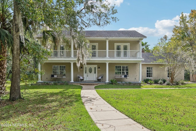 view of front facade featuring a porch, a front lawn, and a balcony