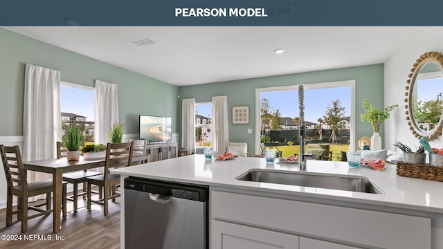 kitchen featuring stainless steel dishwasher, dark wood-style floors, a sink, visible vents, and light countertops
