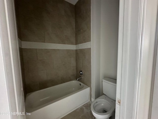 bathroom with tiled shower / bath combo and toilet