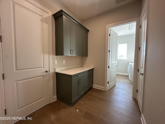 bar featuring dark wood-type flooring and baseboards