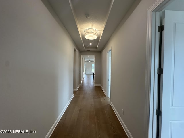 hallway with dark wood-style floors and baseboards