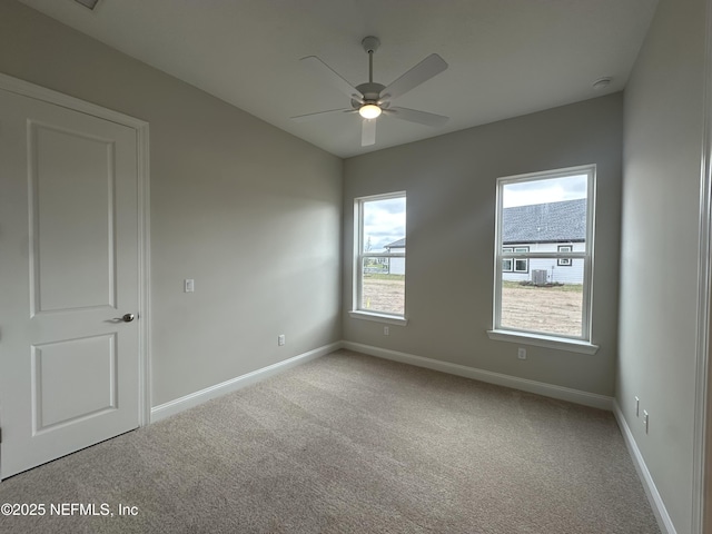 empty room featuring carpet, baseboards, and ceiling fan