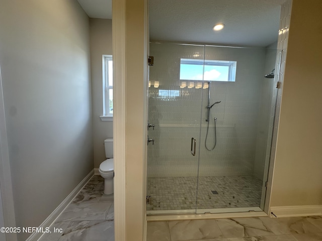 full bathroom featuring marble finish floor, a stall shower, toilet, and baseboards