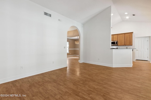 unfurnished living room with vaulted ceiling and light hardwood / wood-style floors