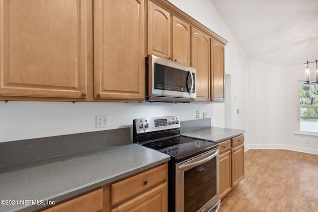 kitchen with lofted ceiling, light wood-type flooring, and appliances with stainless steel finishes