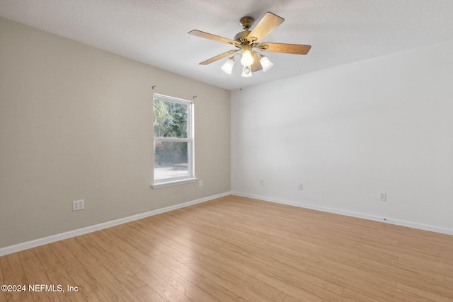 unfurnished room featuring a textured ceiling, light wood-type flooring, and ceiling fan