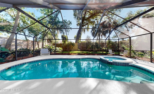 view of swimming pool with a lanai and an in ground hot tub