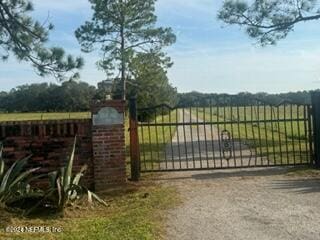 view of gate with a rural view