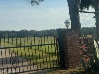 view of gate with a rural view