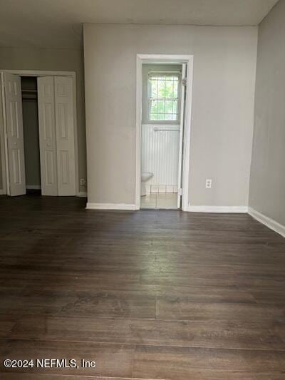 unfurnished room with dark hardwood / wood-style flooring