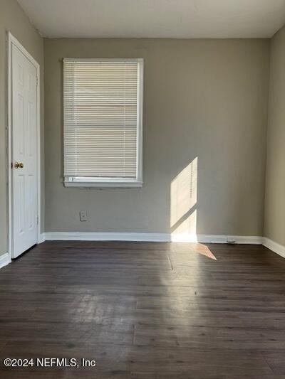 spare room with dark wood-type flooring