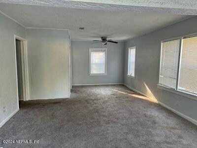 unfurnished room featuring ceiling fan and carpet floors