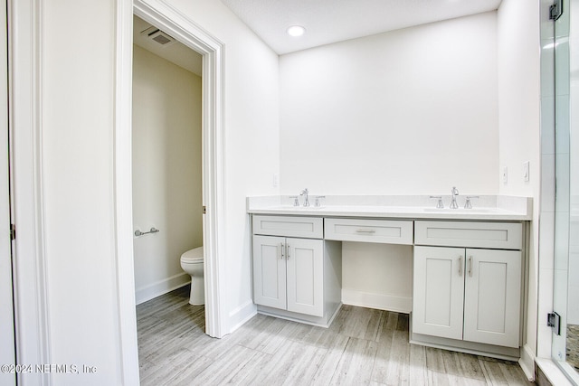 bathroom with wood-type flooring, vanity, and toilet