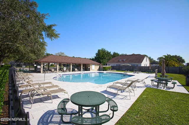 view of pool with a lawn and a patio area