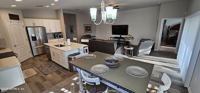 kitchen with stainless steel appliances, dark hardwood / wood-style floors, an island with sink, and white cabinets