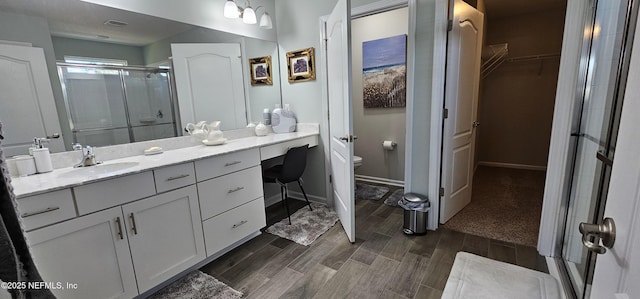 bathroom with vanity, toilet, and an enclosed shower