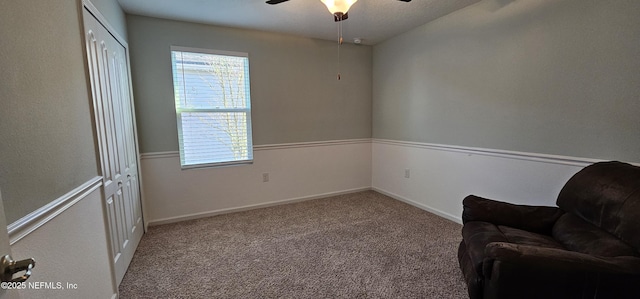 living area with ceiling fan and light carpet