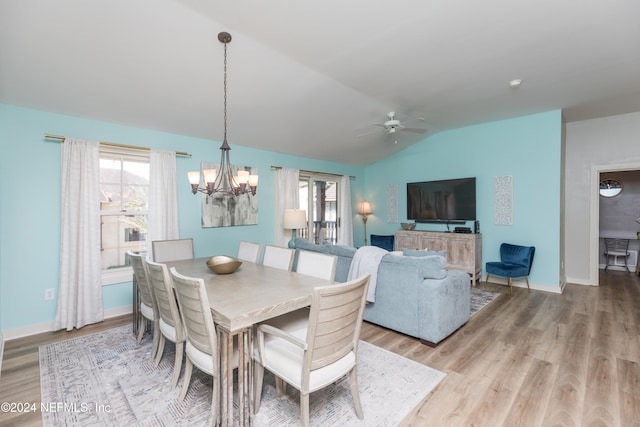 dining space featuring light hardwood / wood-style flooring, vaulted ceiling, and ceiling fan with notable chandelier