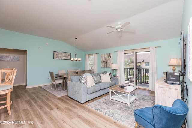 living room with wood-type flooring, vaulted ceiling, and ceiling fan with notable chandelier