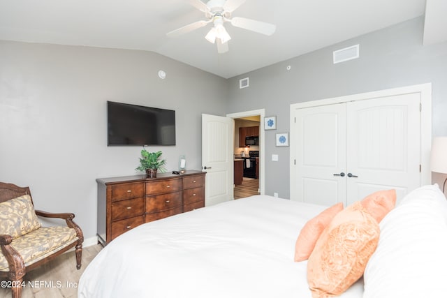 bedroom featuring vaulted ceiling, wood-type flooring, a closet, and ceiling fan