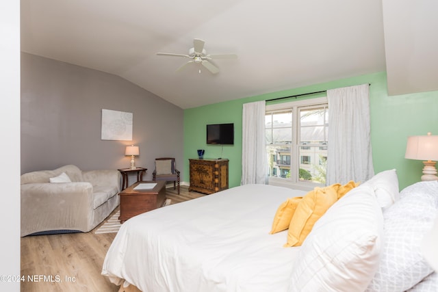 bedroom featuring ceiling fan, vaulted ceiling, and light hardwood / wood-style flooring