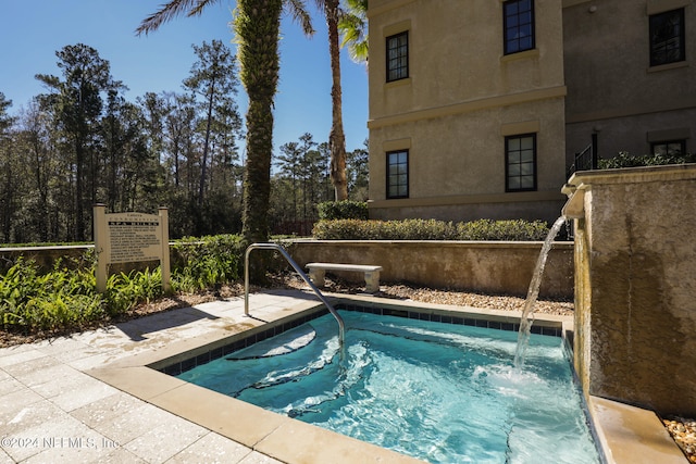 view of swimming pool with a hot tub