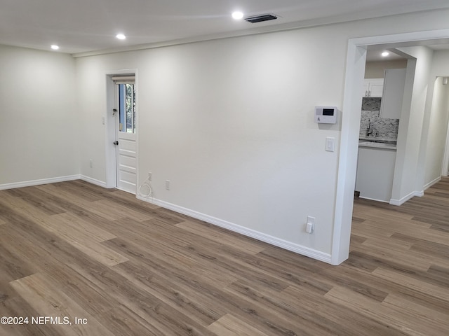 empty room featuring light hardwood / wood-style floors and sink