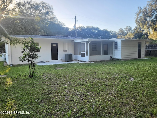 back of house featuring a patio area, central AC, a lawn, and a sunroom