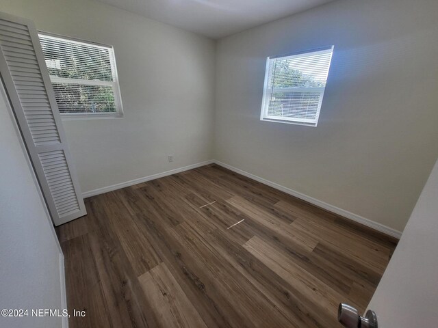 unfurnished room featuring dark wood-type flooring