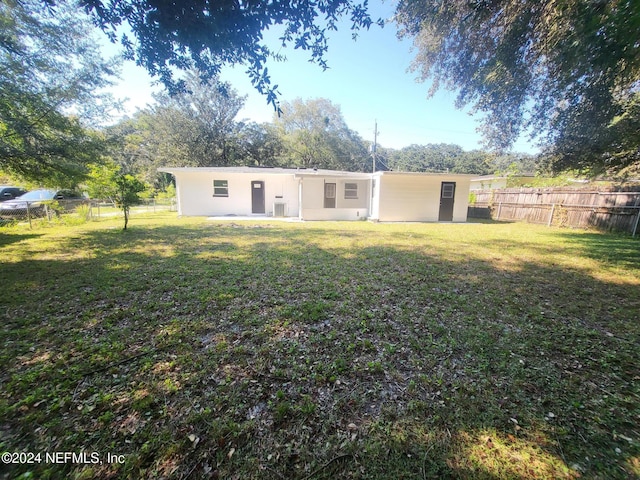 rear view of house featuring a lawn