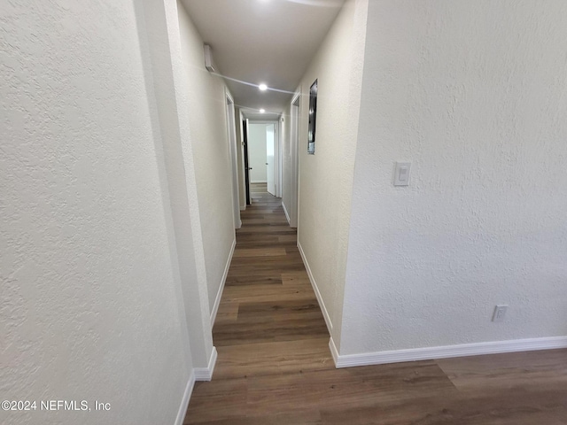 corridor with dark hardwood / wood-style flooring