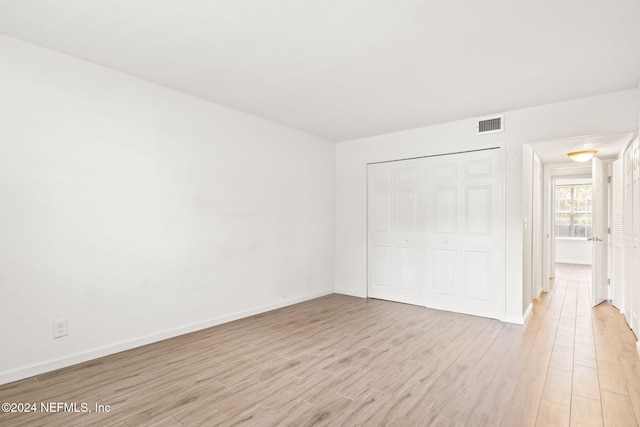 unfurnished bedroom featuring a closet and light hardwood / wood-style floors