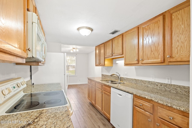 kitchen featuring light stone counters, an inviting chandelier, light hardwood / wood-style flooring, sink, and white appliances