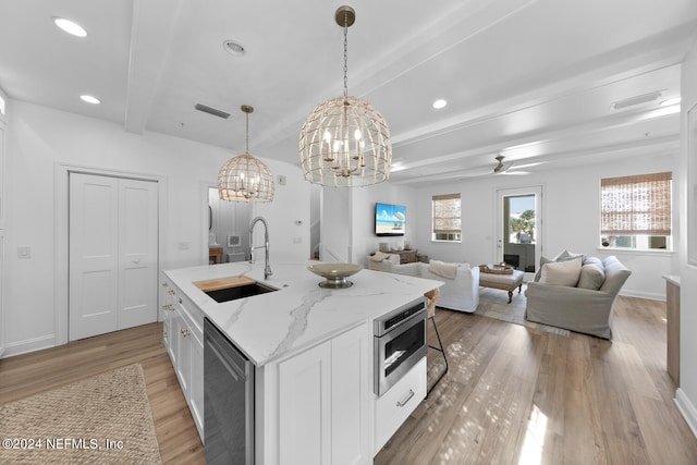 kitchen featuring beamed ceiling, white cabinets, sink, light hardwood / wood-style floors, and appliances with stainless steel finishes