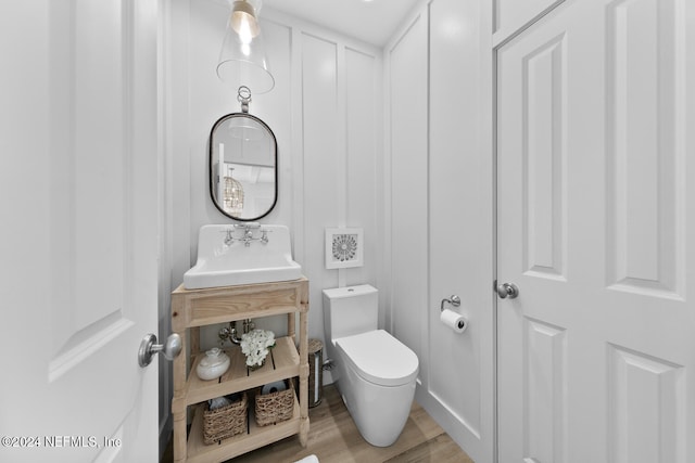 bathroom with wood-type flooring, vanity, and toilet