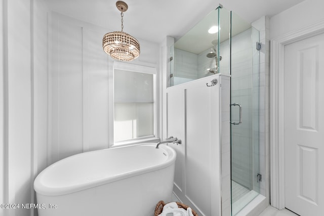 bathroom with an inviting chandelier and shower with separate bathtub